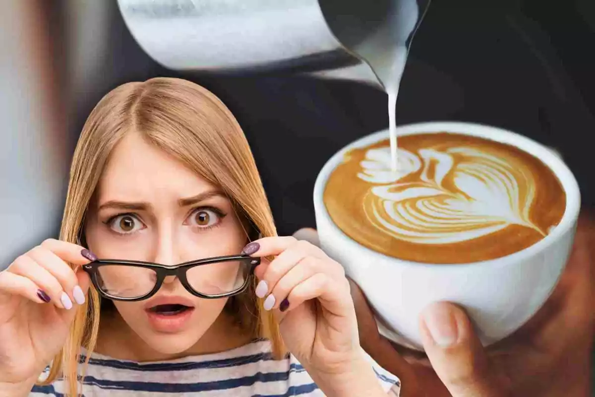 Una mujer con expresión de sorpresa sostiene sus gafas mientras observa una taza de café con arte latte. Una mujer con expresión de sorpresa sostiene sus gafas mientras observa una taza de café con arte latte.
