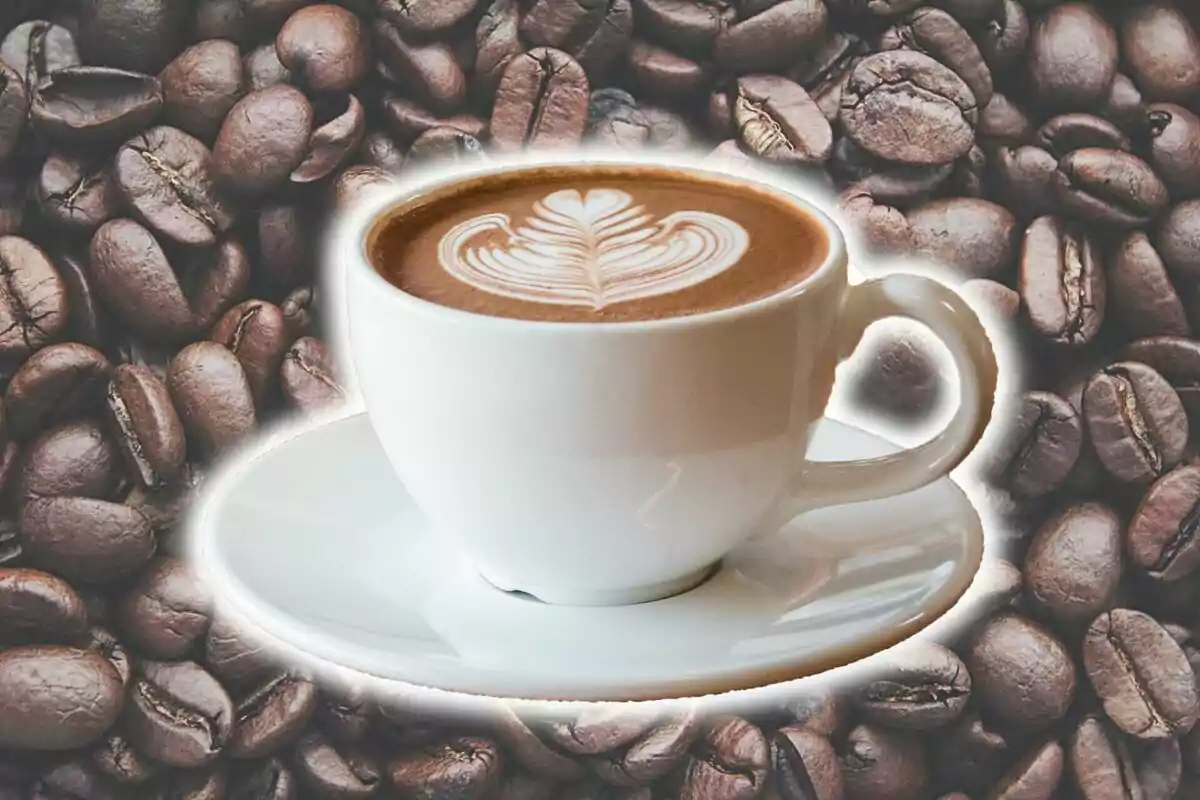 Una taza de café con arte latte sobre un fondo de granos de café. Una taza de café con arte latte sobre un fondo de granos de café.