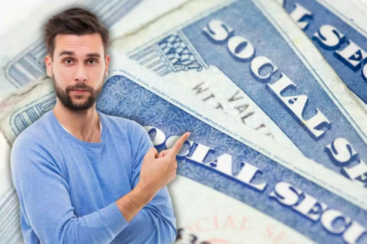 Hombre con barba y suéter azul señalando hacia varias tarjetas de seguro social de Estados Unidos en el fondo