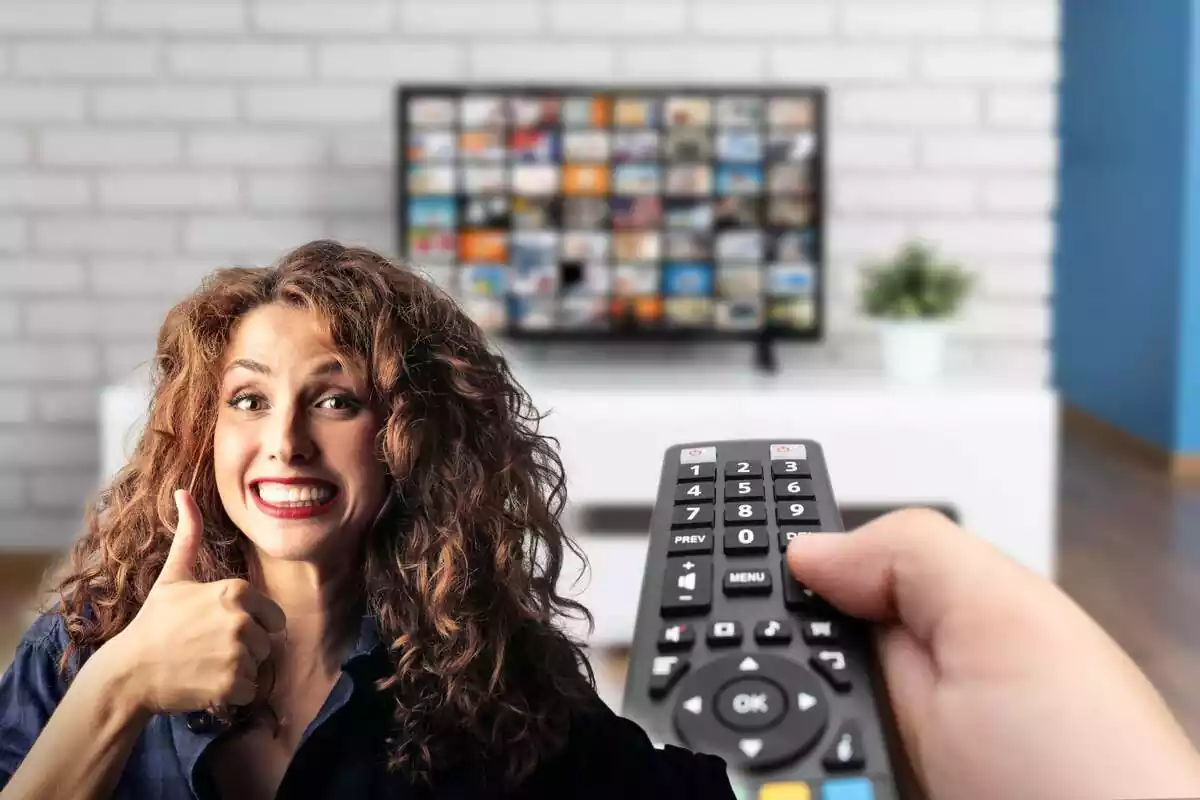 A person with a remote control and a television in the background, while on the left a smiling woman gives a thumbs up