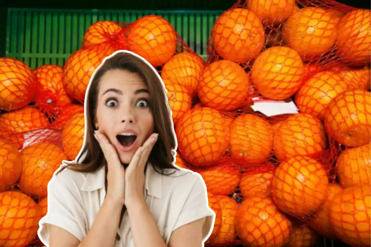 Una persona con expresión de sorpresa frente a una pila de naranjas en mallas rojas.