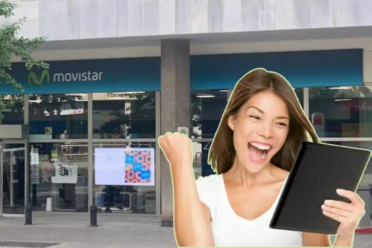 Mujer feliz con una tableta frente a una tienda de Movistar