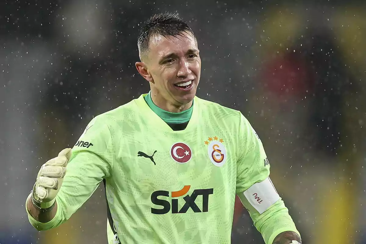 Portero de fútbol con uniforme verde claro y guantes blancos durante un partido bajo la lluvia Portero de fútbol con uniforme verde claro y guantes blancos durante un partido bajo la lluvia