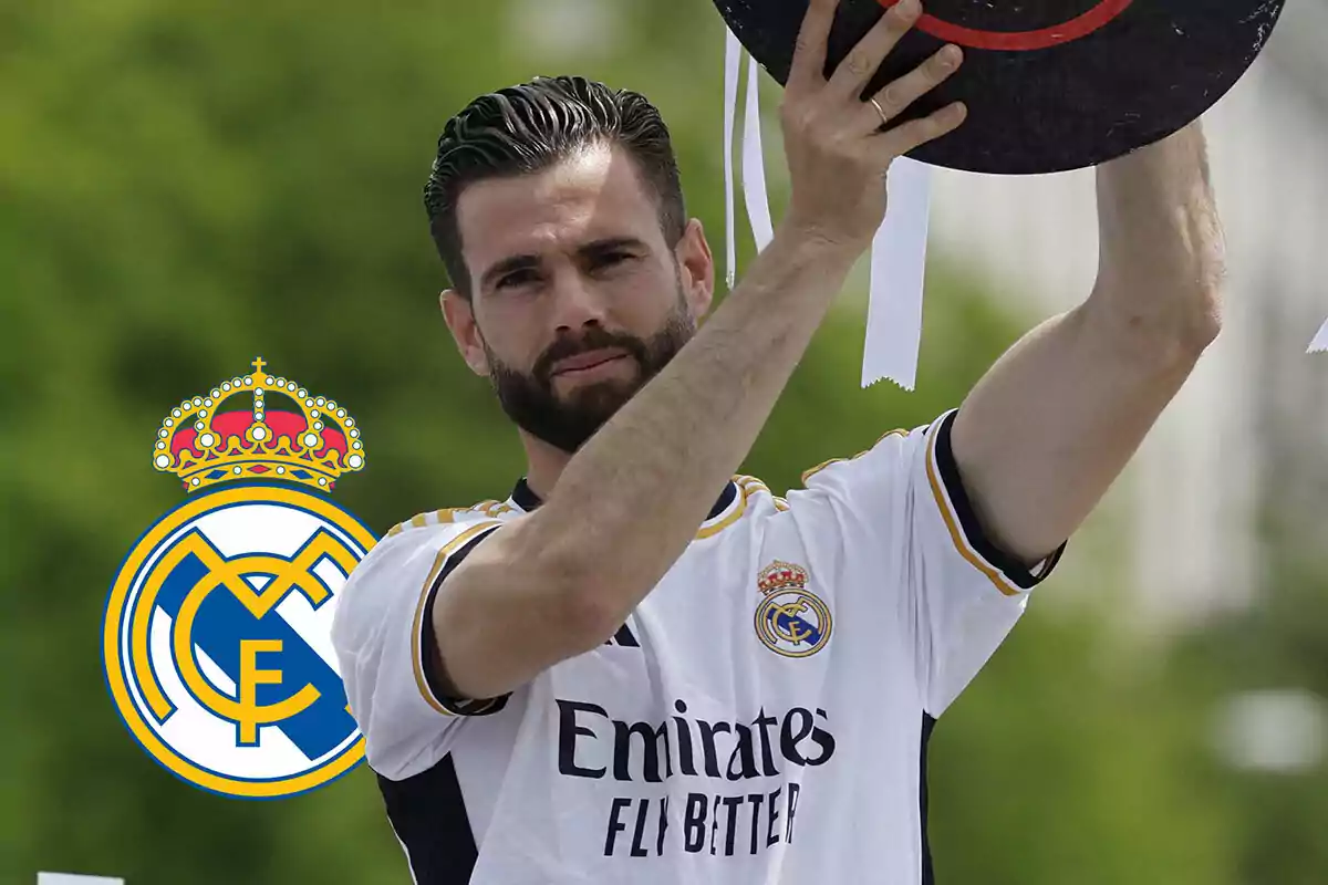 Nacho Fernández levantando un trofeo con el escudo del Real Madrid en el fondo.