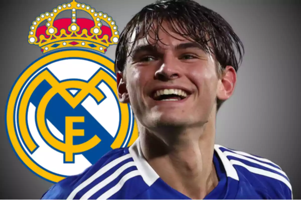 Un jugador de fútbol sonriente con el escudo del Real Madrid de fondo.