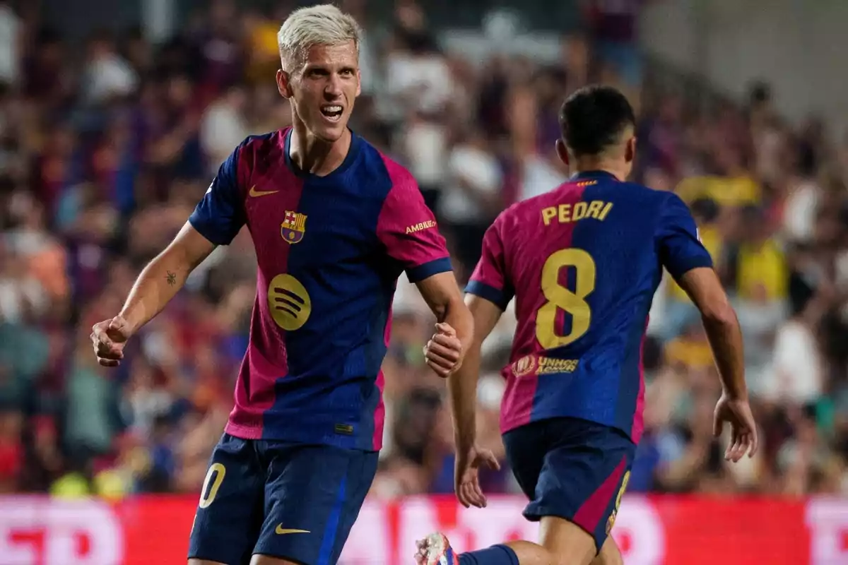 Dos jugadores del FC Barcelona celebran durante un partido, uno de ellos con el número 8 y el nombre "Pedri" en su camiseta.