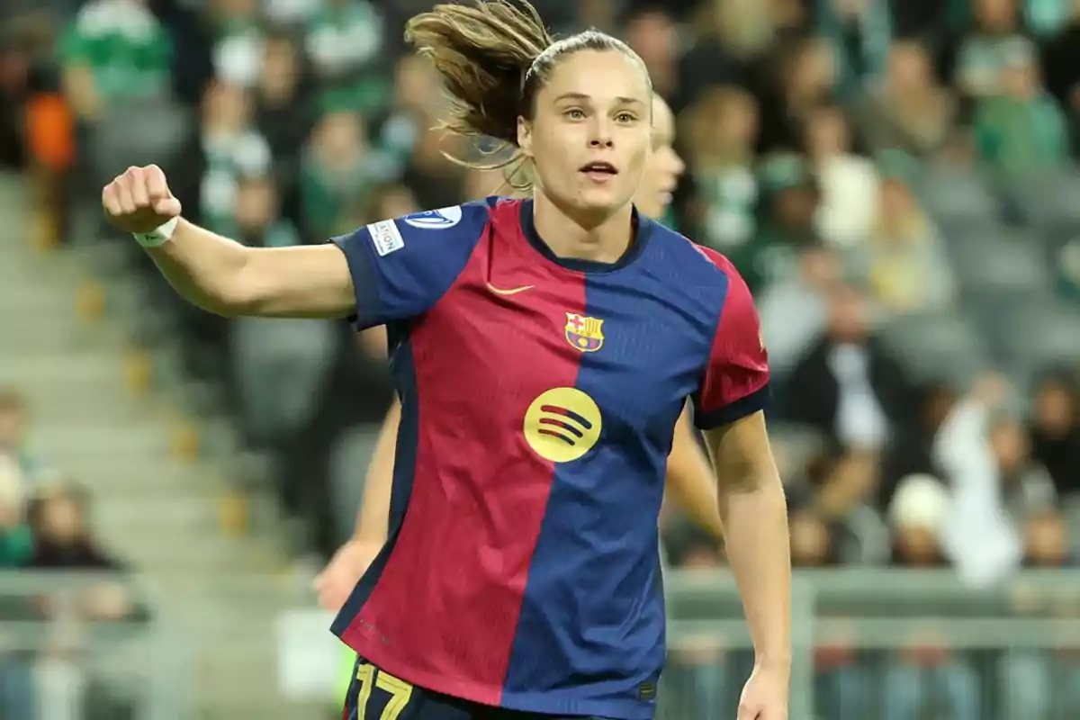 Female soccer player in FC Barcelona uniform celebrating on the field. Female soccer player in FC Barcelona uniform celebrating on the field.