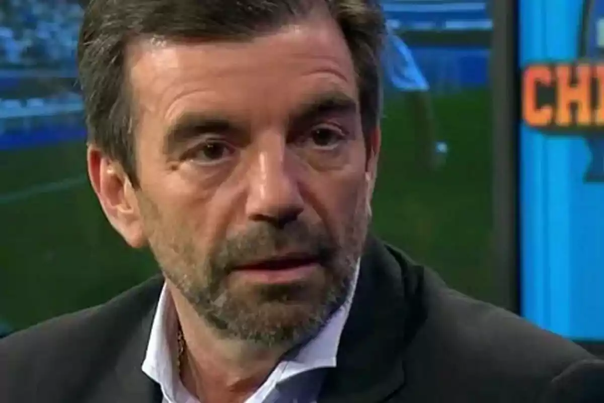 Un hombre con barba y cabello oscuro en un estudio de televisión. Un hombre con barba y cabello oscuro en un estudio de televisión.