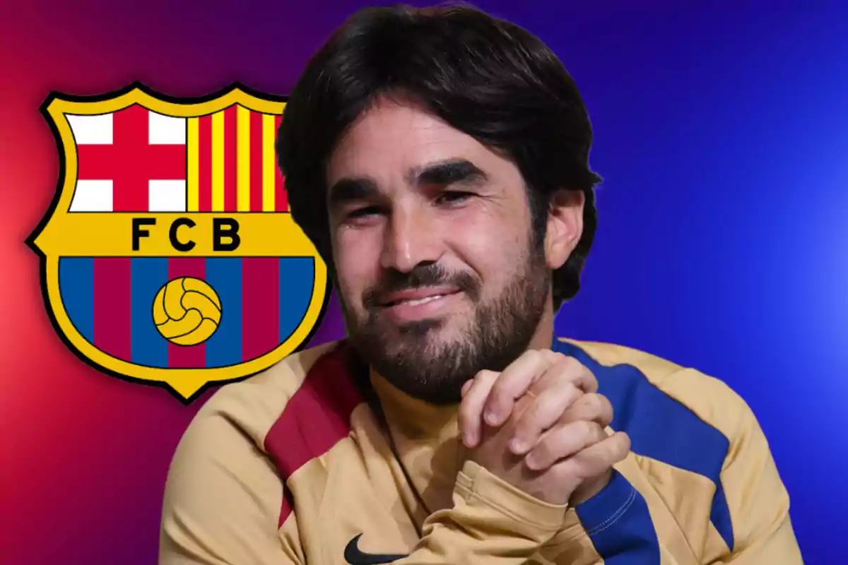 Un hombre sonriente con barba y cabello oscuro, vistiendo una camiseta con los colores del FC Barcelona, con el escudo del club en el fondo.