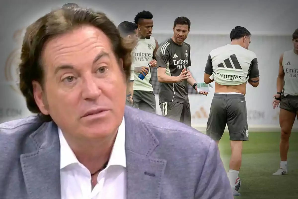 A brown-haired man in a gray jacket appears in the foreground, while in the background several players and a soccer coach can be seen on a Real Madrid training field.