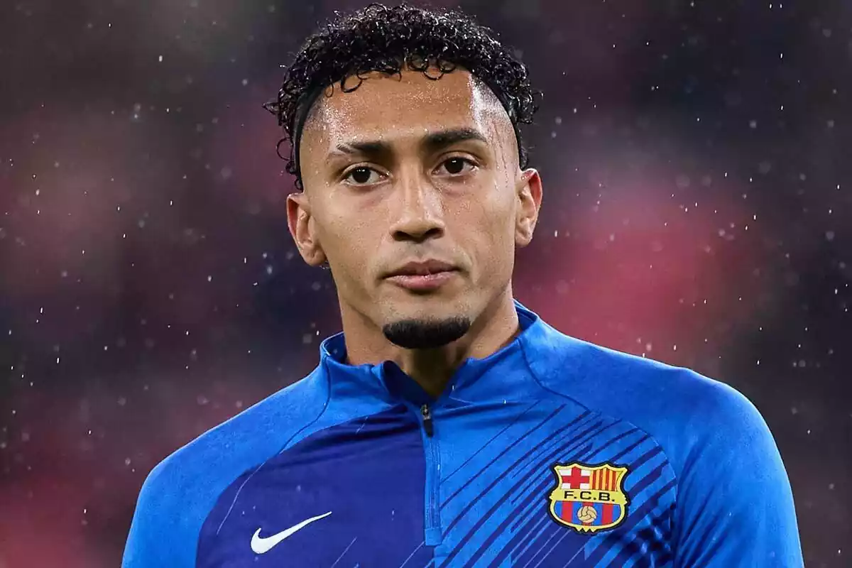 Raphinha con la camiseta del FC Barcelona mirando al frente bajo la lluvia