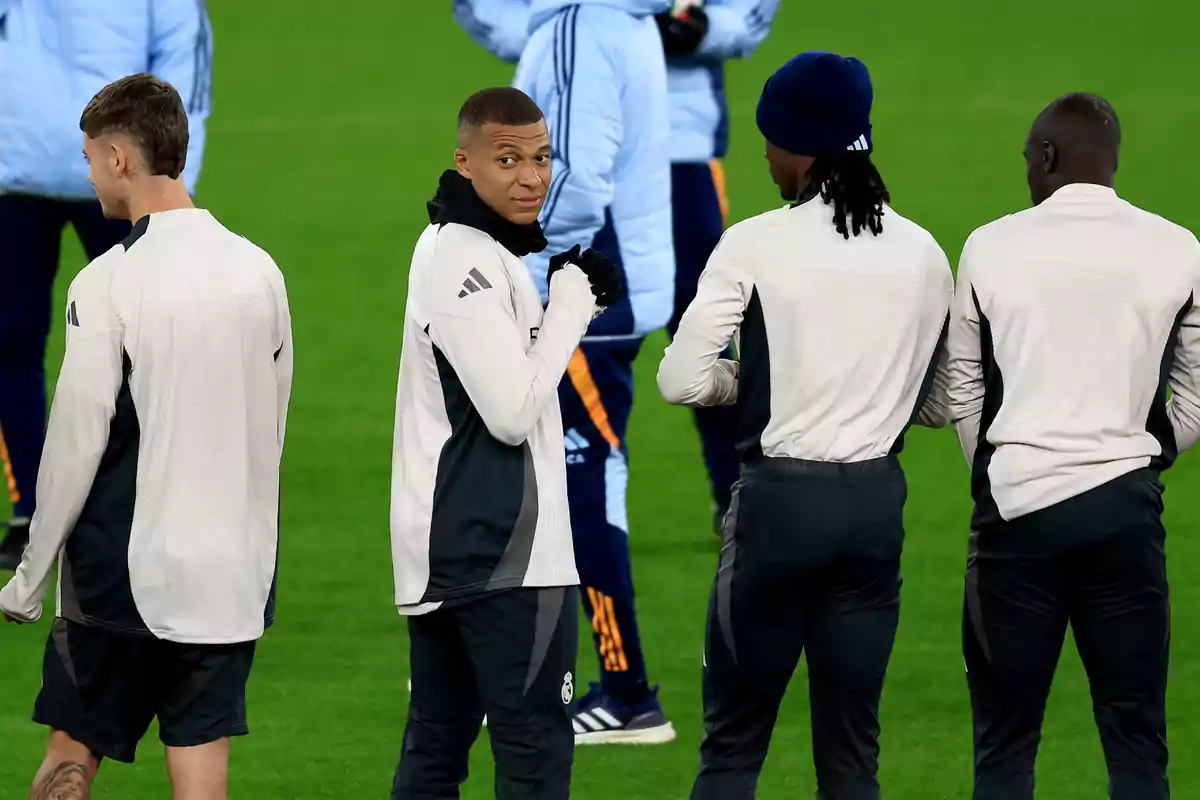 Football players on the field during training in sports uniforms.