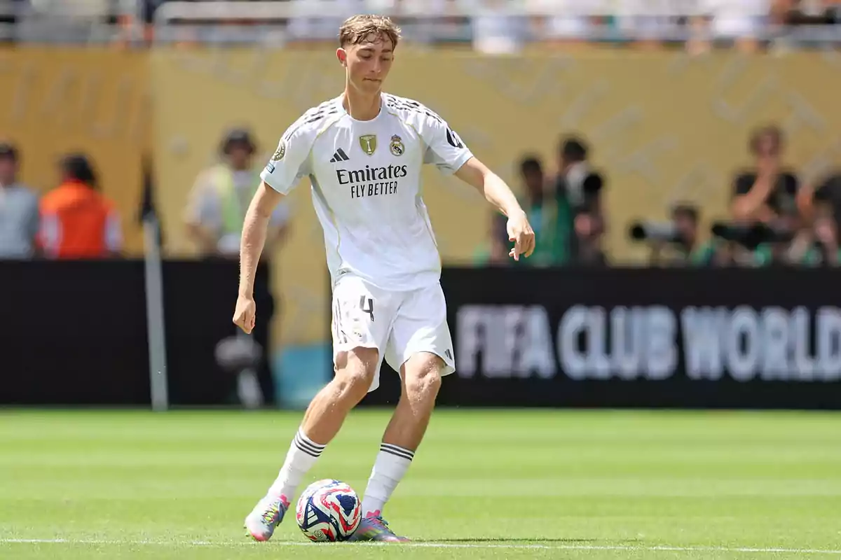 Futbolista del Real Madrid controlando el balón durante un partido en un estadio lleno de espectadores Futbolista del Real Madrid controlando el balón durante un partido en un estadio lleno de espectadores