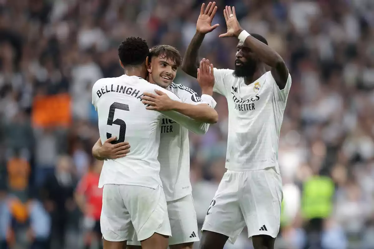 Three Real Madrid soccer players celebrate on the field with expressions of joy. Three Real Madrid soccer players celebrate on the field with expressions of joy.