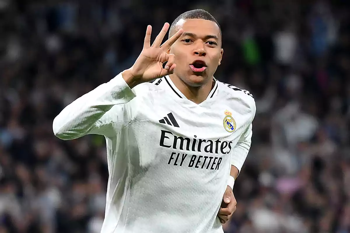 A player in a white uniform celebrates on the field by making a hand gesture.