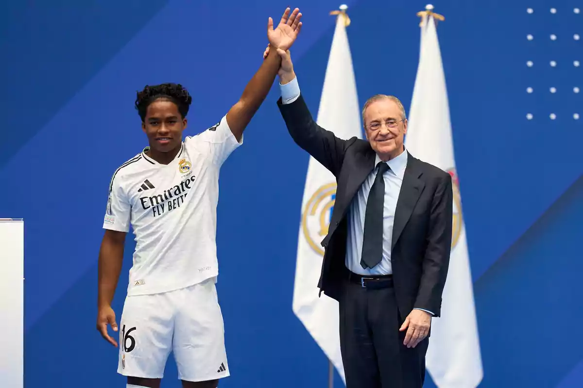 Two people at a sporting event raise their arms in celebration against a blue background with flags.