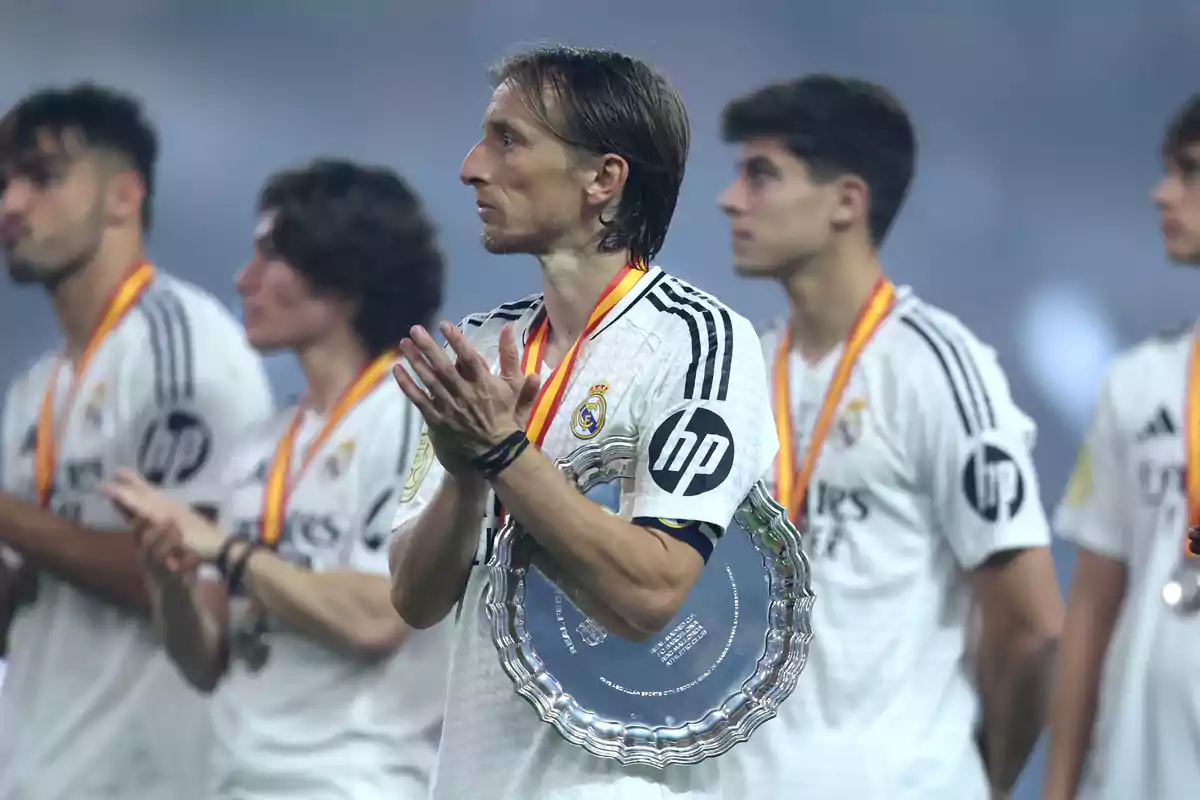 Football players with medals and a trophy at an awards ceremony. Football players with medals and a trophy at an awards ceremony.