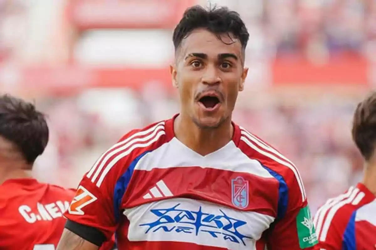 Un jugador de fútbol con uniforme rojo y blanco celebra en el campo. Un jugador de fútbol con uniforme rojo y blanco celebra en el campo.