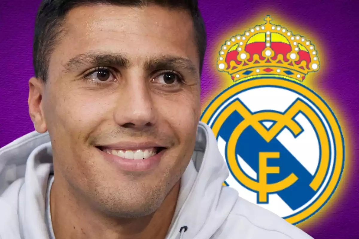 A man smiling with the Real Madrid logo in the background.