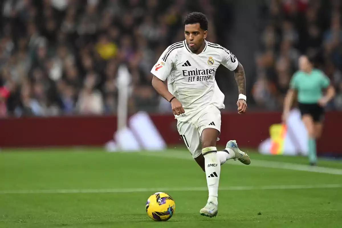 A player from Real Madrid runs with the ball on the field during a match.