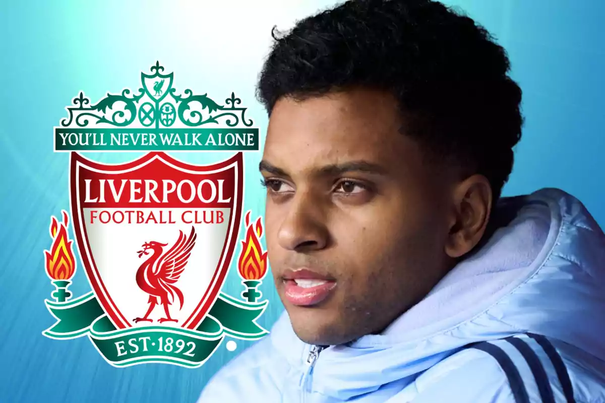 Un hombre con una chaqueta azul claro aparece junto al escudo del Liverpool Football Club sobre un fondo azul.