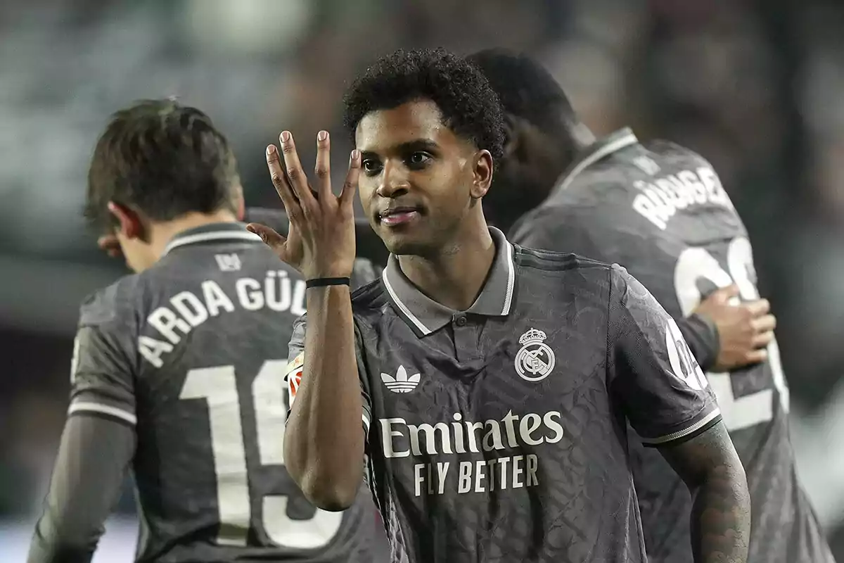 Rodrygo celebra en el campo mientras otros jugadores del Real Madrid están en segundo plano.