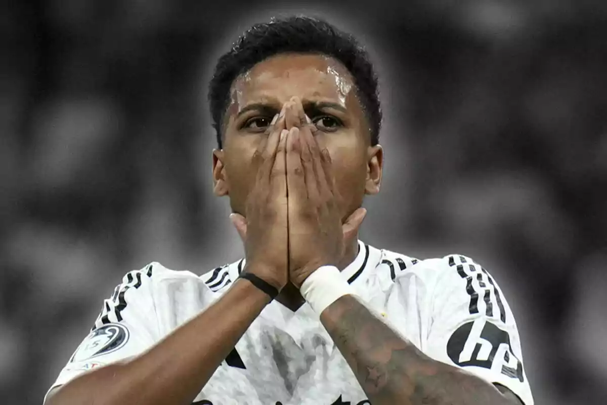 Rodrygo Goes con expresión de sorpresa o preocupación, vistiendo un uniforme blanco y negro, con las manos juntas frente a su rostro.