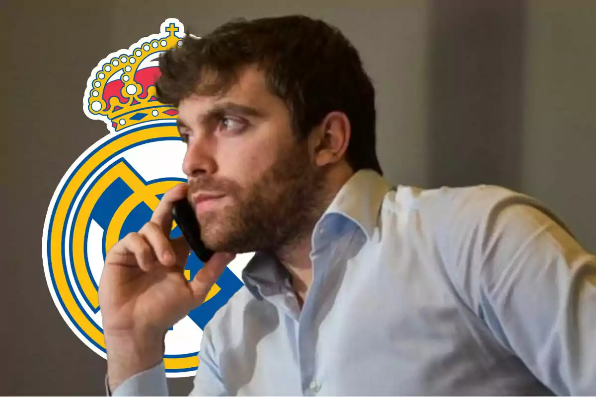 Fabrizio Romano hablando por teléfono con el logo del Real Madrid de fondo.