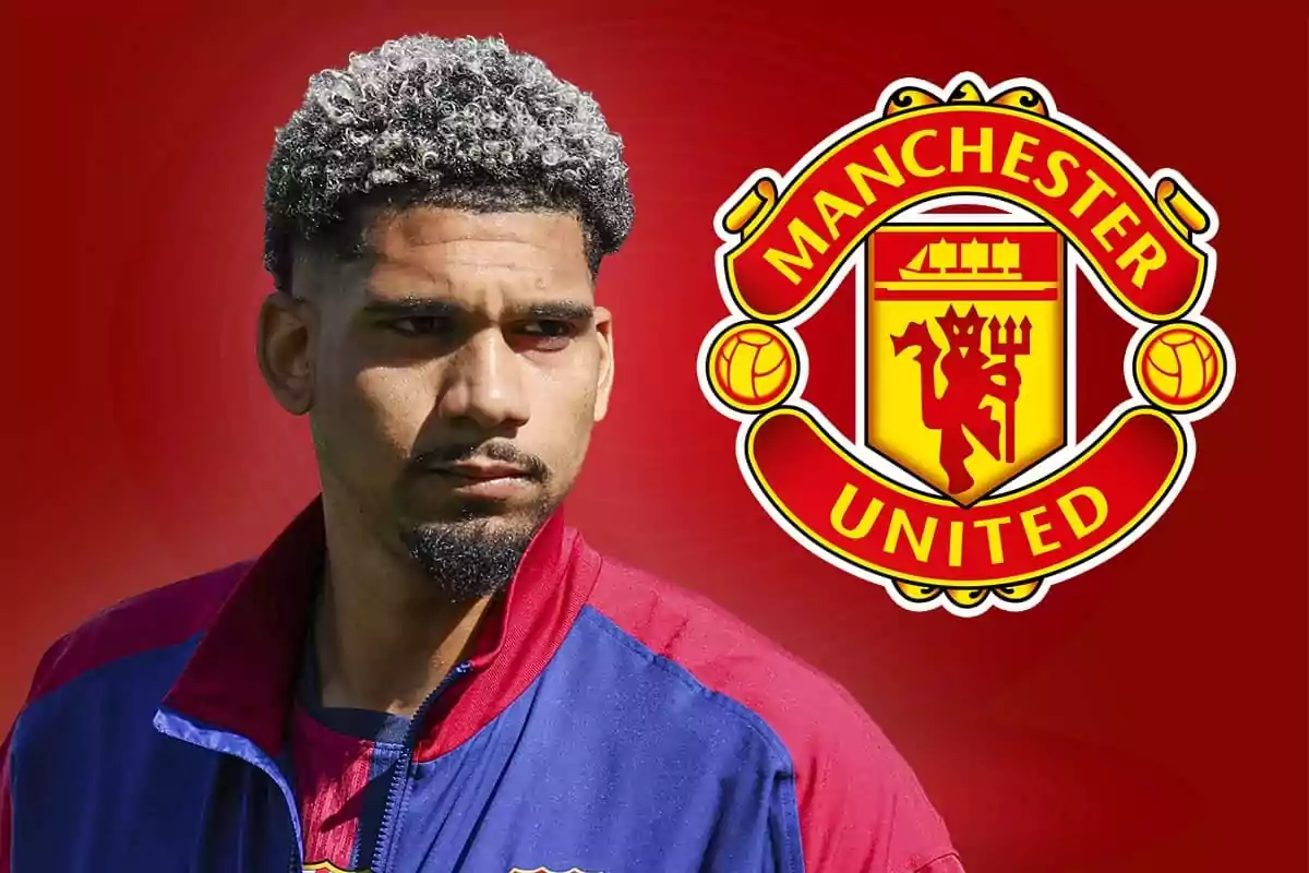 Un hombre con chaqueta azul y roja está frente a un fondo rojo con el escudo del Manchester United.