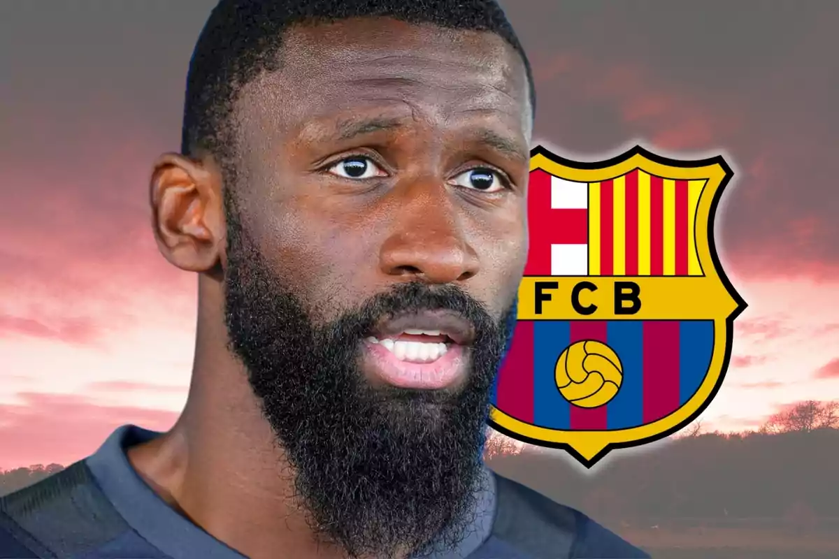 A bearded man in front of a FC Barcelona crest against a sunset background.