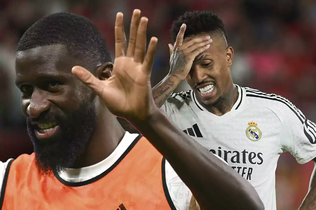 Dos jugadores de fútbol del Real Madrid en el campo, Rüdiger sonriendo y levantando la mano y Militao con gesto de frustración.