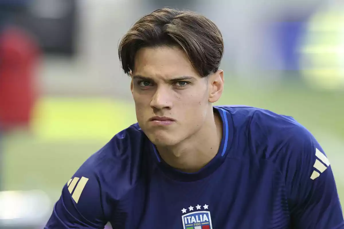 Samuele Ricci in a blue Italy jersey looks on with a serious expression.