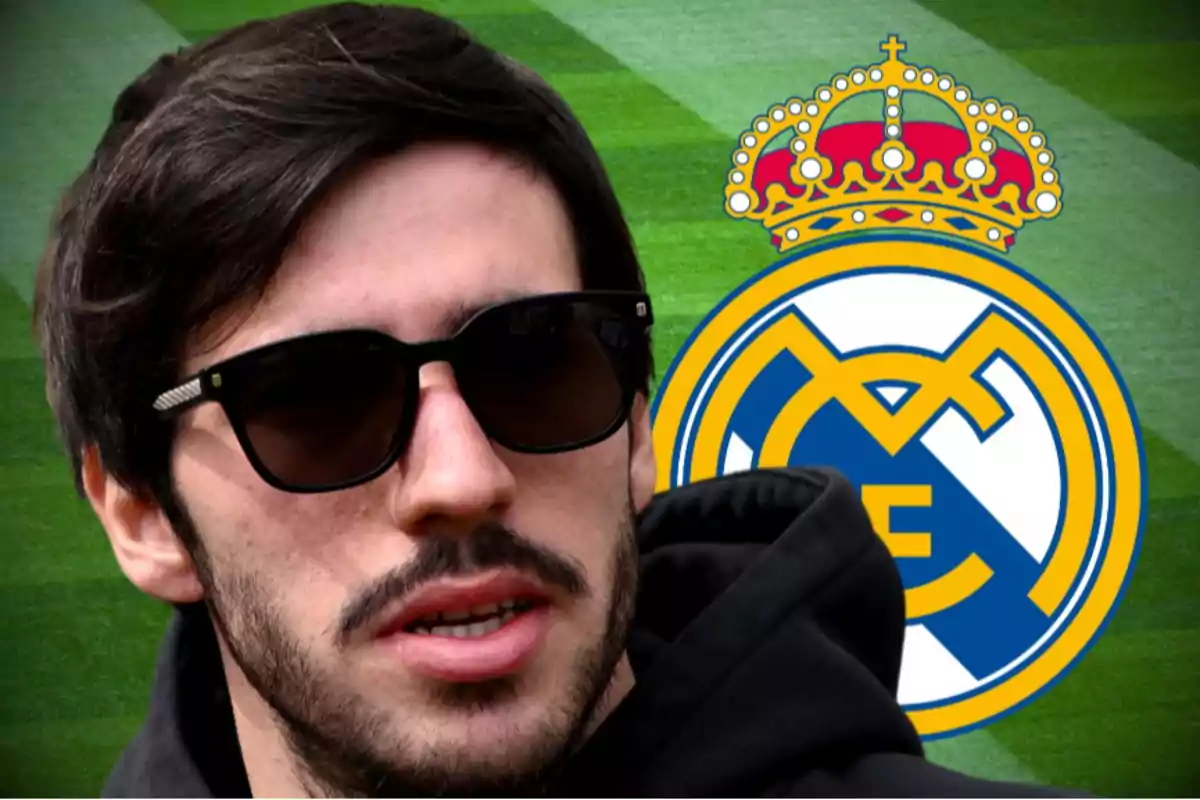 A man with sunglasses and a beard in front of the Real Madrid logo on a grass background.