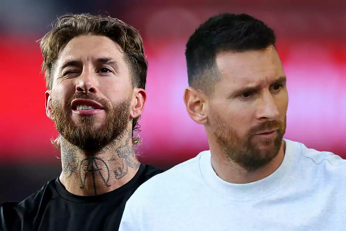 Dos hombres con barba, Sergio Ramos con tatuajes en el cuello y guiñando un ojo, y Messi con una expresión seria, con un fondo desenfocado en tonos rojos.