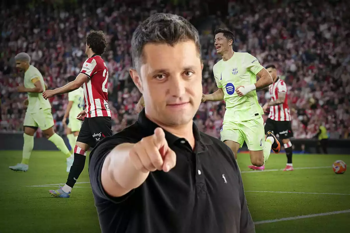 Un hombre en primer plano señala hacia el frente mientras detrás se desarrolla un partido de fútbol con jugadores en acción.
