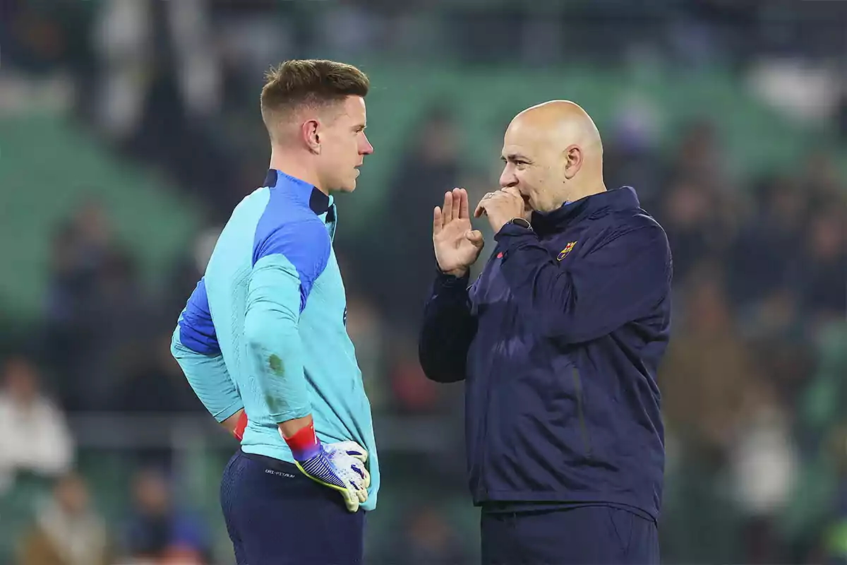 Un entrenador de fútbol conversa con un portero en el campo antes de un partido Un entrenador de fútbol conversa con un portero en el campo antes de un partido
