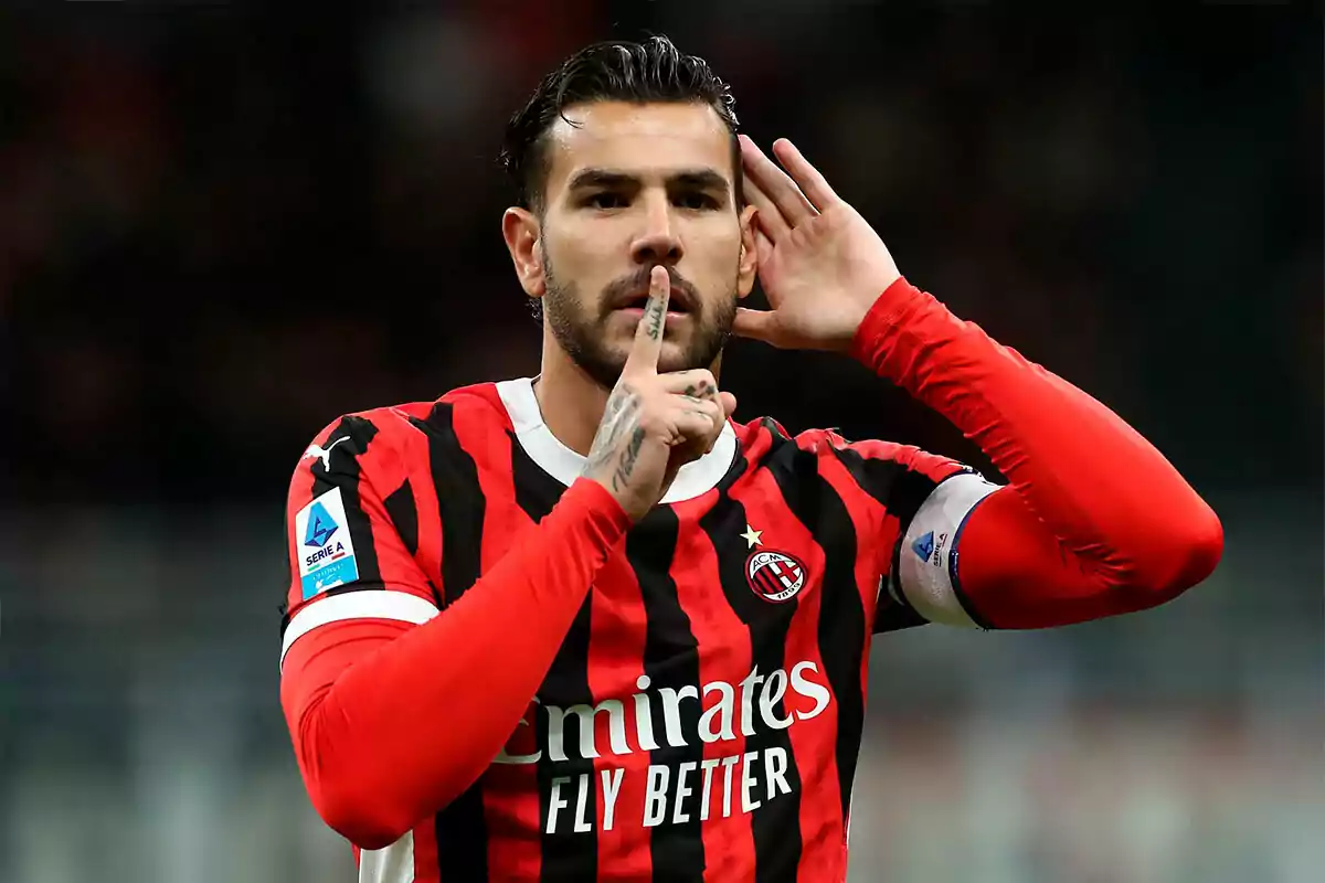 A player in a red and black uniform makes a shushing gesture with a finger on his lips while bringing the other hand to his ear.