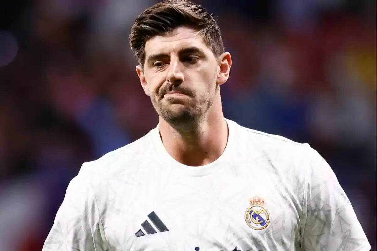 A football player in a white Real Madrid shirt on the field.