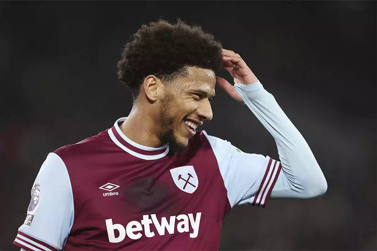 Futbolista del West Ham sonríe mientras se toca la cabeza durante un partido Futbolista del West Ham sonríe mientras se toca la cabeza durante un partido