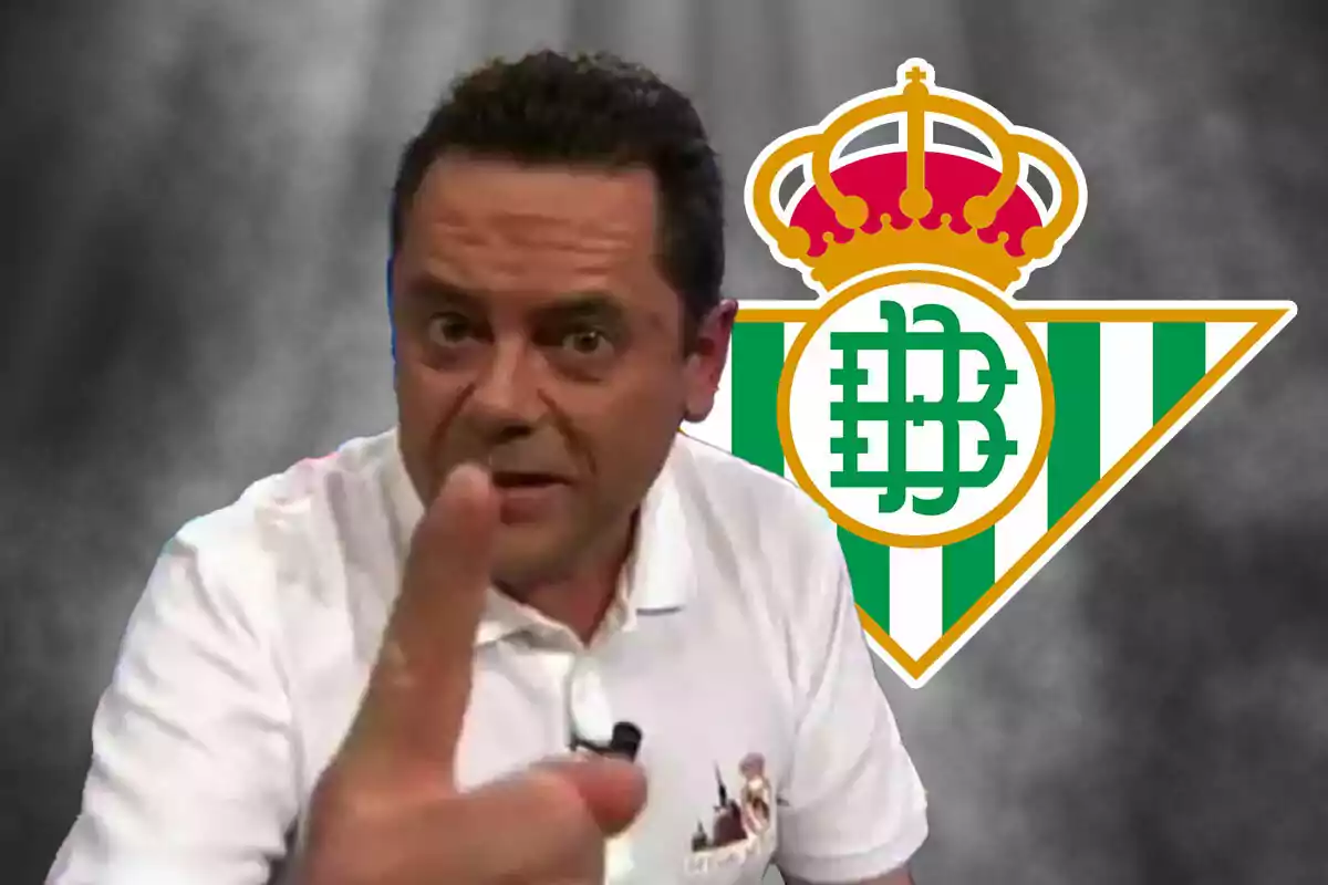 Un hombre señalando con el dedo frente a un logo del Real Betis.