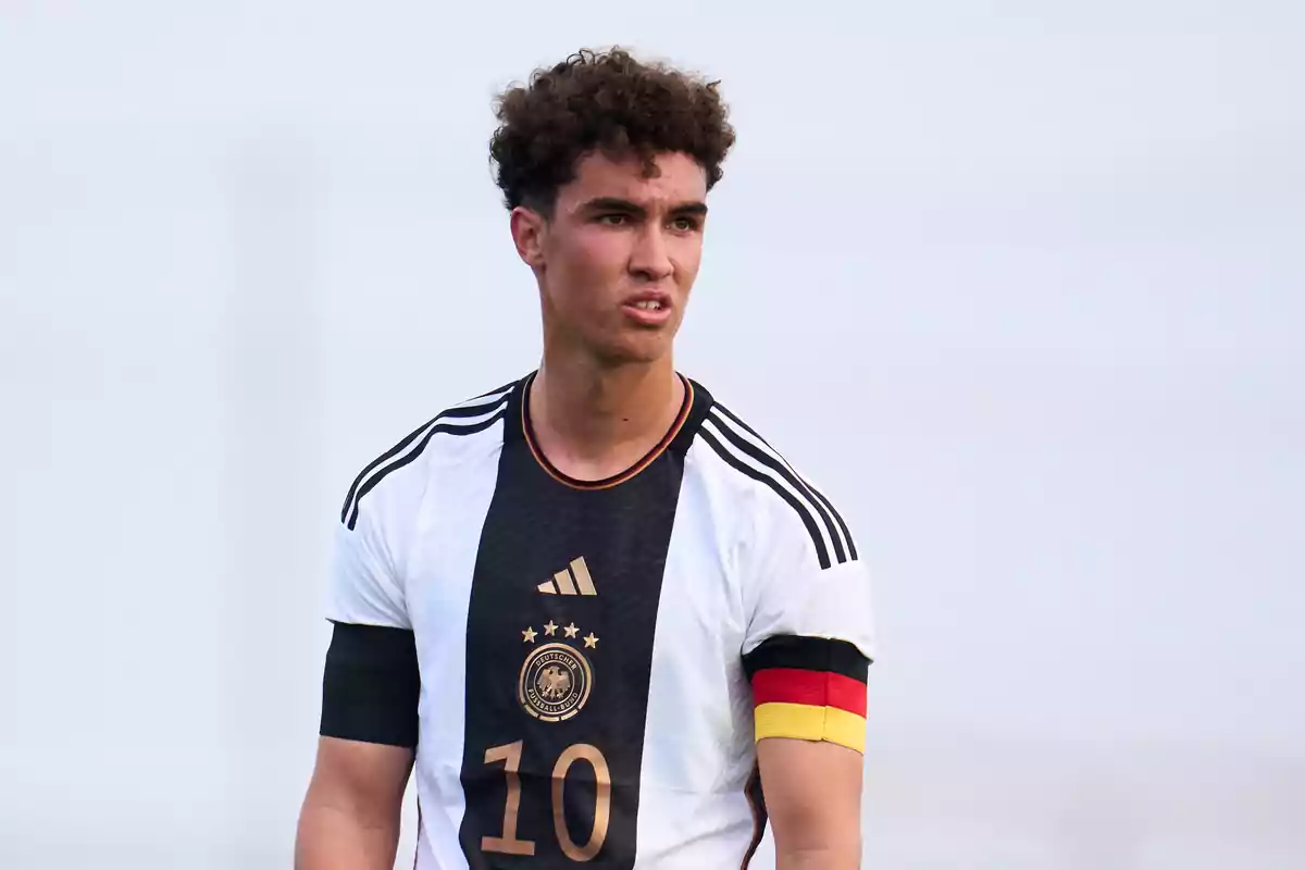 A soccer player in a Germany uniform with a captain's armband.