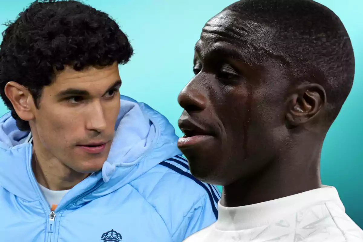 Two people looking at each other with serious expressions, one wearing a blue jacket and the other a white t-jersey, against a light blue background.