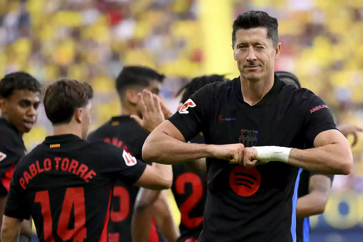 Jugadores de fútbol del FC Barcelona celebran en el campo, en primer plano el goleador, Lewandowski.