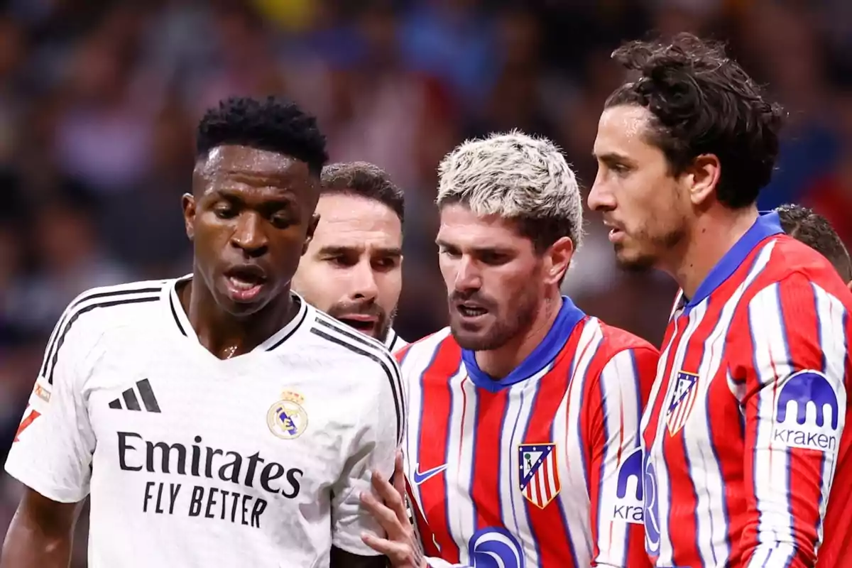 Jugadores de fútbol de dos equipos diferentes discuten en el campo durante un partido.