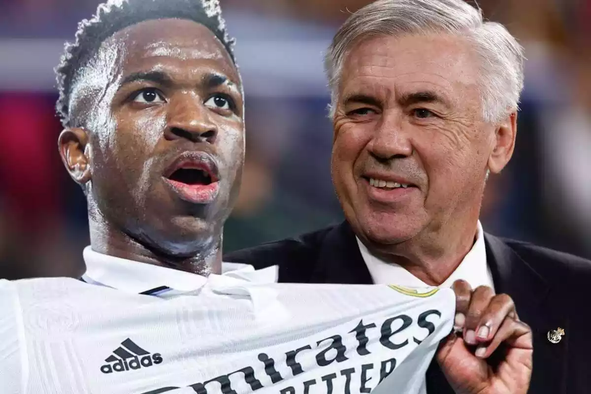 Vinícius Júnior points to the Real Madrid shield with Carlo Ancelotti at his side