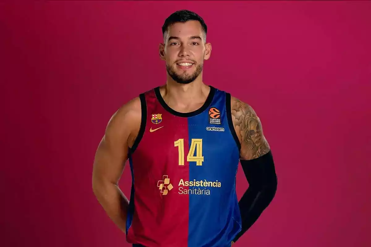 Jugador de baloncesto con uniforme del FC Barcelona, número 14, posando frente a un fondo rosa Jugador de baloncesto con uniforme del FC Barcelona, número 14, posando frente a un fondo rosa