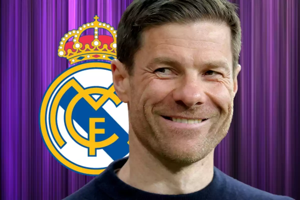 A smiling man in front of a background with a soccer team's crest.